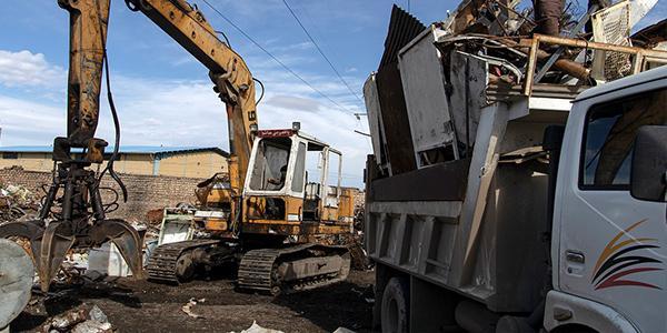 廢棄物清運過程，一輛載滿建築廢料的清運車準備離開工地